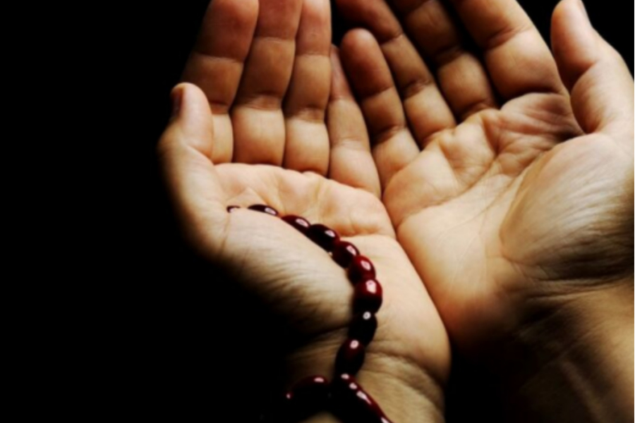 Opening hands holding prayer beads